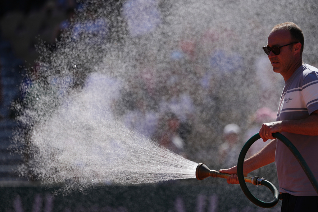 A stadium worker sprays the court with water before the first round men's singles tennis match at the French Open tennis tournament in Paris, Monday, May 25, 2026. (AP Photo/Aurelien Morissard)