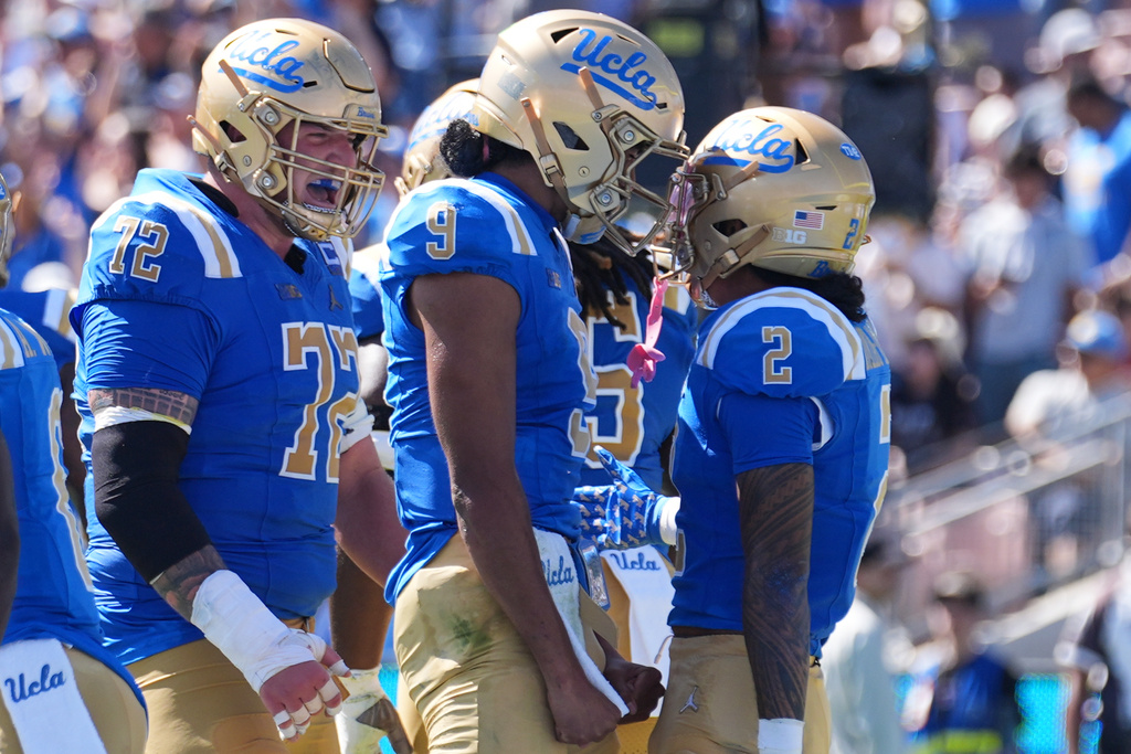 UCLA wide receiver Titus Mokiao-Atimalala (2) celebrates his touchdown catch with quarterback Nico Iamaleava (9) during the first half of an NCAA college football game against Penn State Saturday, Oct. 4, 2025, in Pasadena, Calif. (AP Photo/Marcio Jose Sanchez)