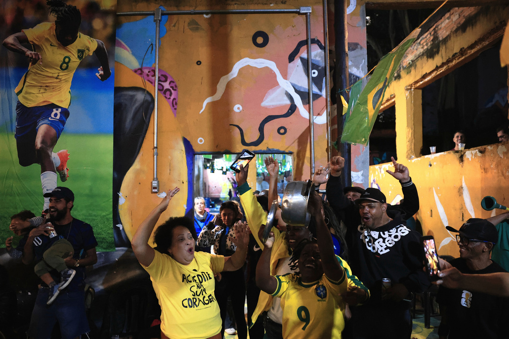 Fans celebrate a goal scored by Brazil against Morocco during a World Cup watch party at a housing occupation run by the Homeless Workers Movement, in Sao Paulo, Brazil, Saturday, June 13, 2026. (AP Photo/Ettore Chiereguini)