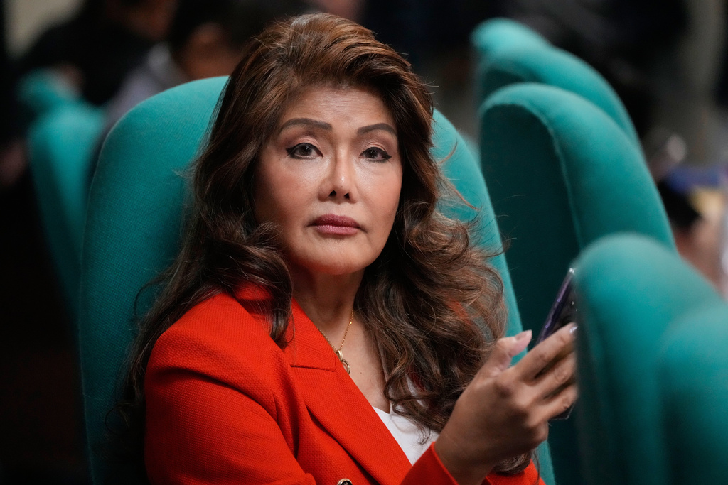 Senator Imee Marcos checks her phone during a break at a Senate hearing in Manila, Philippines on March 20, 2025. (AP Photo/Aaron Favila)