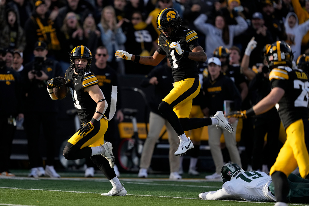 Iowa wide receiver Kaden Wetjen, left, returns a punt for a touchdown during the first half of an NCAA college football game against Michigan State, Saturday, Nov. 22, 2025, in Iowa City, Iowa. (AP Photo/Charlie Neibergall)