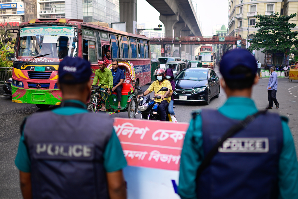 Security personnel stand guard at a traffic intersection as ousted Prime Minister Sheikh Hasina and her former ruling Awami League party called for a nationwide "lockdown" in protest against her trial, in Dhaka, Bangladesh, Thursday, Nov. 13, 2025. (AP Photo/Mahmud Hossain Opu)