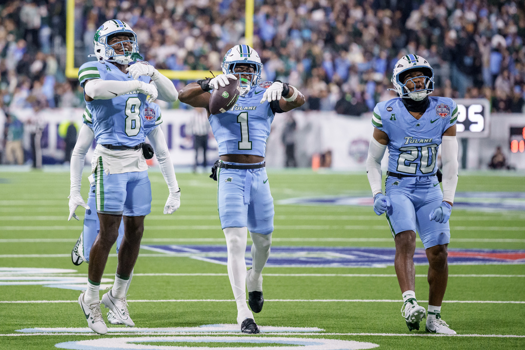 Tulane safety Jack Tchienchou (1) celebrates an interception in the end zone against North Texas wide receiver Wyatt Young during the second half of the American Conference championship NCAA college football game in New Orleans, Friday, Dec. 5, 2025. (AP Photo/Matthew Hinton)