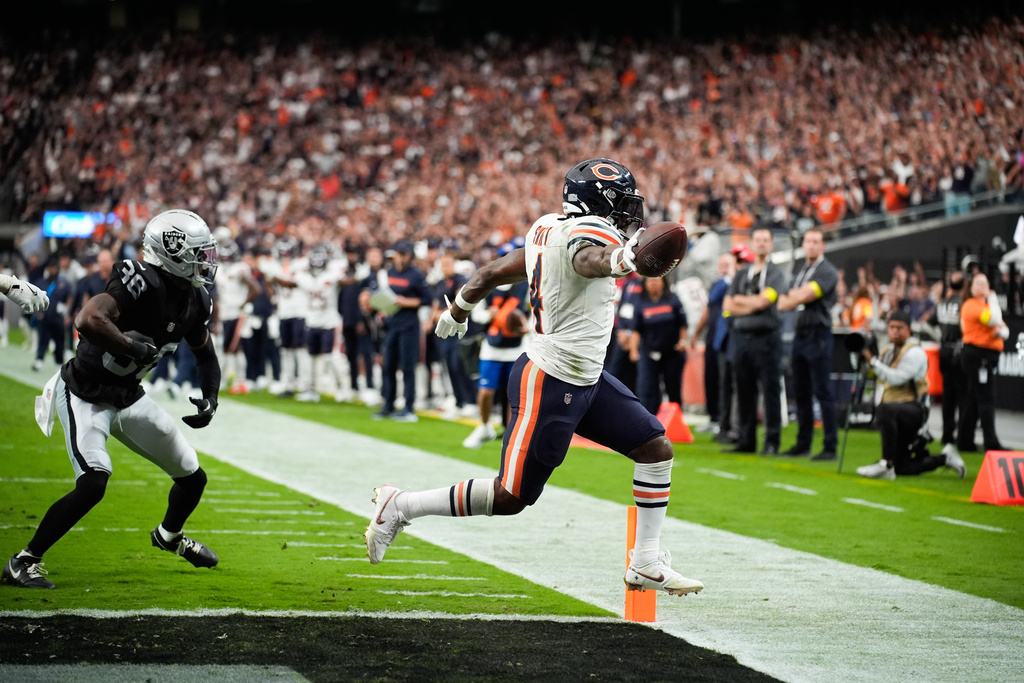 Chicago Bears running back d'Andre Swift (4) scores a touchdown past Las Vegas Raiders cornerback Kyu Blu Kelly (36) during the second half of an NFL football game Sunday, Sept. 28, 2025, in Las Vegas. (AP Photo/John Locher)
