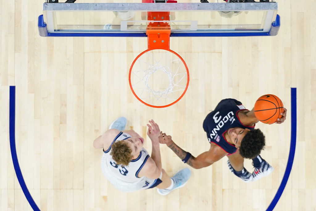 UConn's Jaylin Stewart, right, goes up for a dunk as Villanova's Matt Hodge, left, looks on during the first half of an NCAA college basketball game, Saturday, Feb. 21, 2026, in Philadelphia. (AP Photo/Chris Szagola)
