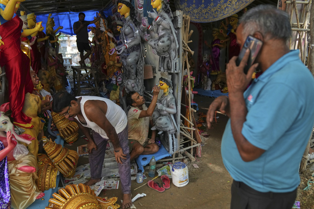 Artists give the final touches to idols of the Hindu goddess Durga ahead of the Durga Puja festival in New Delhi, India, Saturday, Sept. 20, 2025 (AP Photo/Manish Swarup)