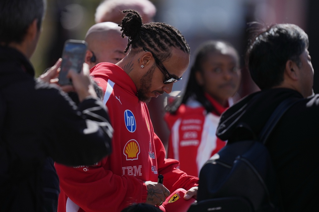Ferrari driver Lewis Hamilton of Britain gives an autograph in Suzuka, central Japan, Thursday, March 26, 2026, ahead of Sunday's Japanese Formula One Grand Prix race. (AP Photo/Hiro Komae)