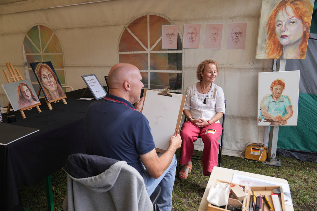 A participant has her portrait done during the Red Head Days festival in Tilburg, Netherlands, Saturday, Aug. 30, 2025. (AP Photo/Virginia Mayo)