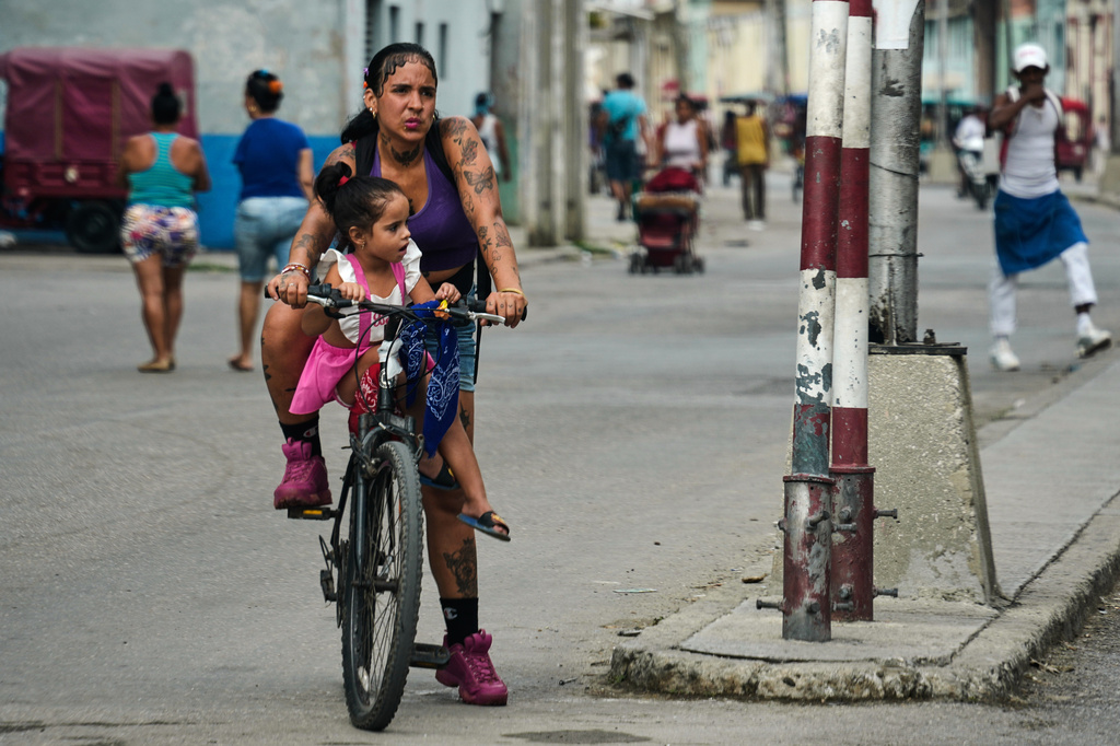 A woman carries a girl on a bicycle in Havana, Cuba, Friday, May 8, 2026. (AP Photo/Ramon Espinosa)