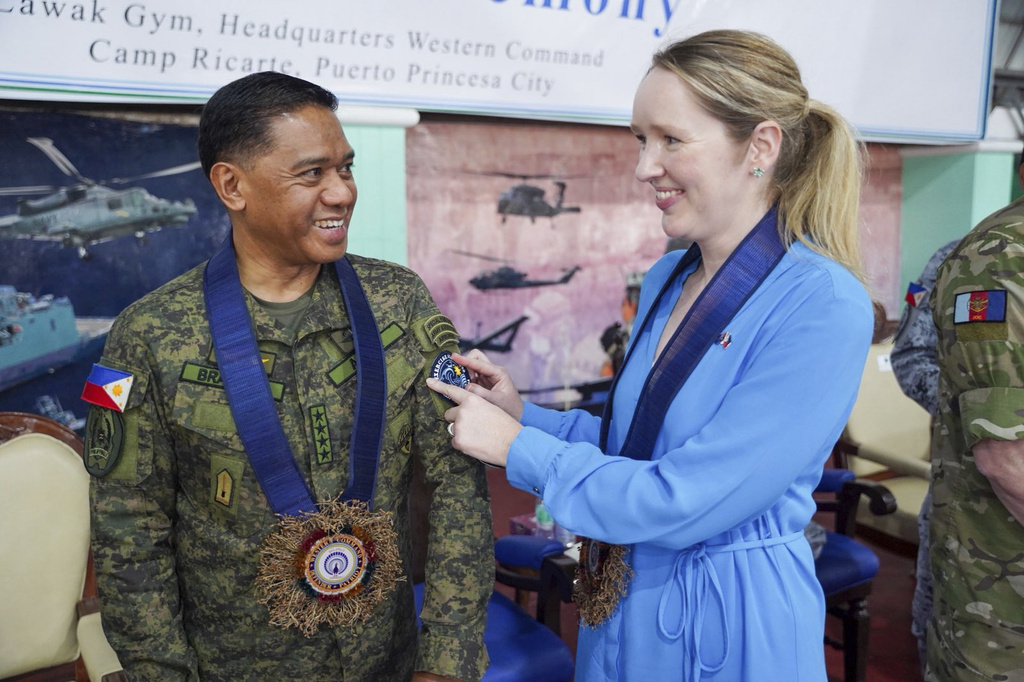 In this photo provided by the Armed Forces of the Philippines, Deputy Ambassador of Australia to the Philippines Moya Collett, left, places the Exercise ALON 2025 patch on military chief General Romeo Brawner Jr. during the opening ceremony of joint military drills between Australia and the Philippines in Palawan province, Philippines on Friday, Aug. 15, 2025. (Armed Forces of the Philippines via AP)