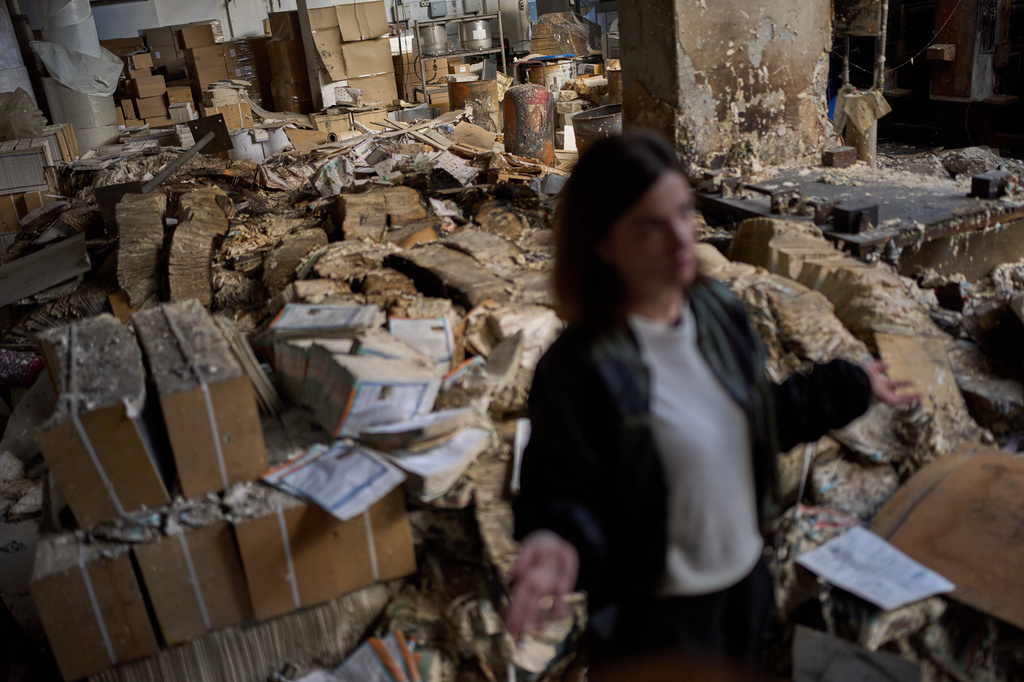 FILE - Viktoria Haidai, the commercial director of the Konvi print shop, gives an interview next to burned books at the destroyed printing house struck by a Russian missile in Kyiv, Ukraine, Sept. 7, 2026. (AP Photo/Francisco Seco, File)