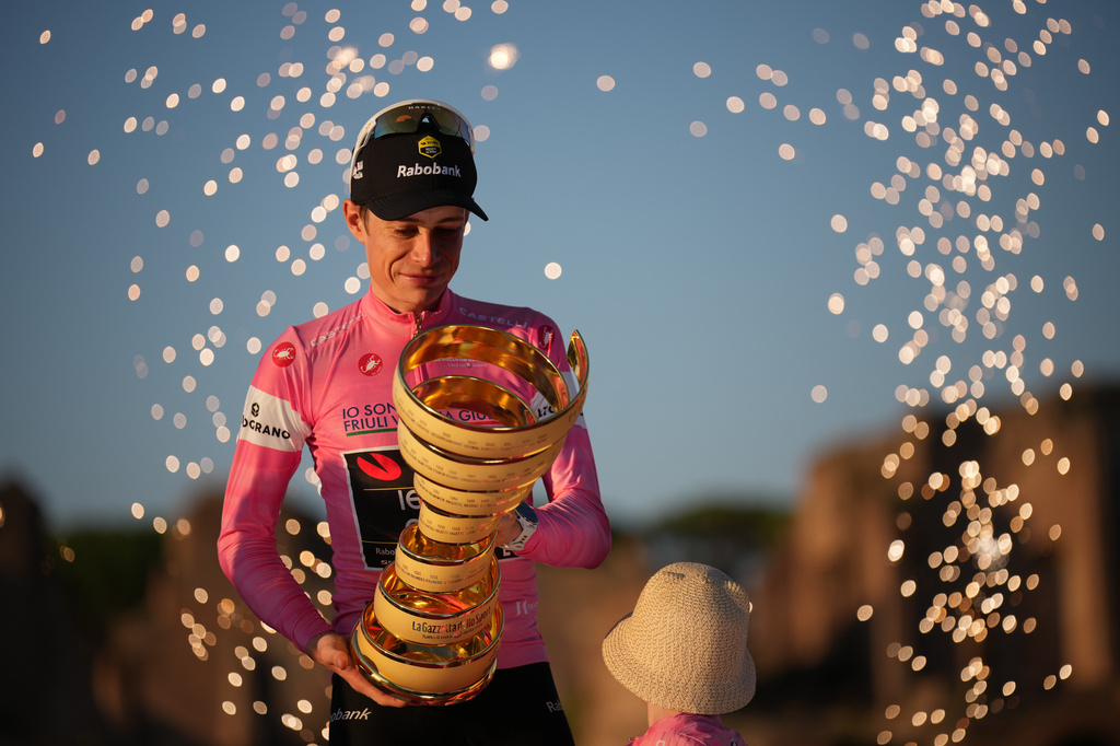 First placed Denmark's Jonas Vingegaard holds the trophy as he celebrates on the podium at the end of the Giro d'Italia cycling race in Rome Sunday, May 31, 2026. (AP Photo/Andrew Medichini)