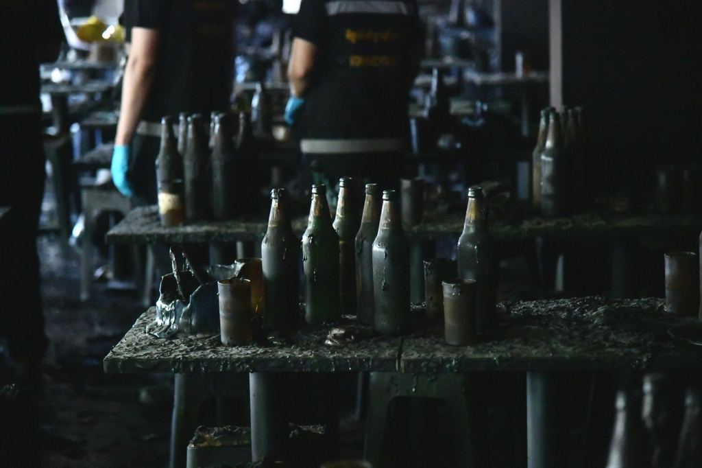 In this handout photo released by Bangkok Metropolitan Administration, bottles are seen on a table at the site of a fire in Bangkok, Thailand, Monday, July 13, 2026. (Bangkok Metropolitan Administration via AP)