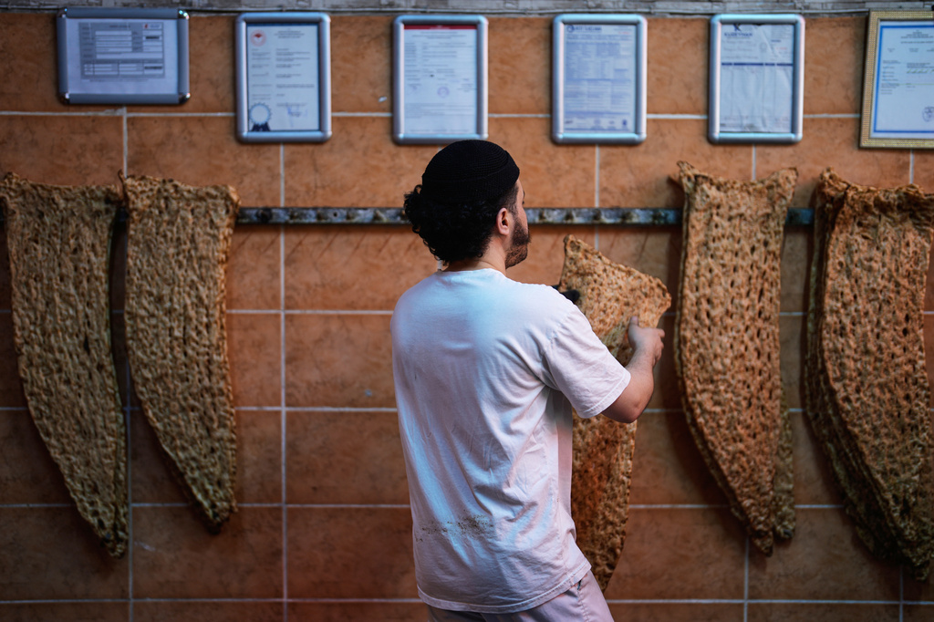 A baker hangs bread in an Iranian bakery in Istanbul on Tuesday, April 14, 2026. (AP Photo/Khalil Hamra)