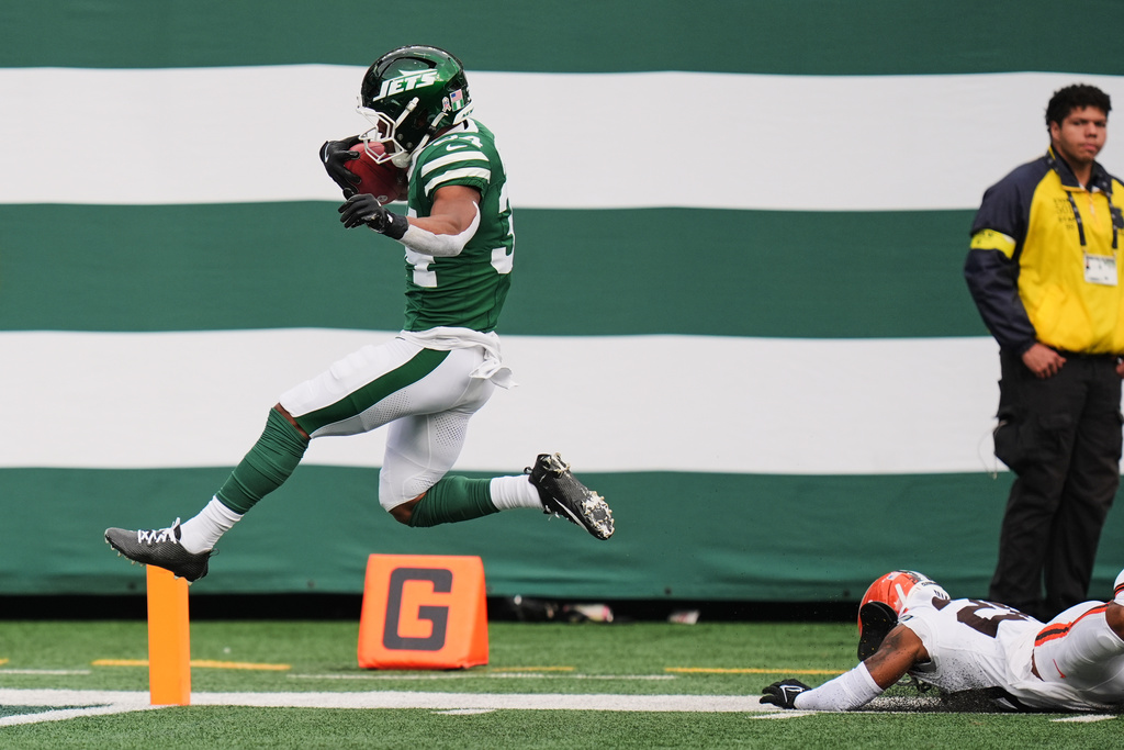 New York Jets running back Kene Nwangwu, left, takes a kickoff return into the end zone for a touchdown in front of Cleveland Browns cornerback Tre Avery, bottom right, in the first half of an NFL football game Sunday, Nov. 9, 2025, in East Rutherford, N.J. (AP Photo/Seth Wenig)