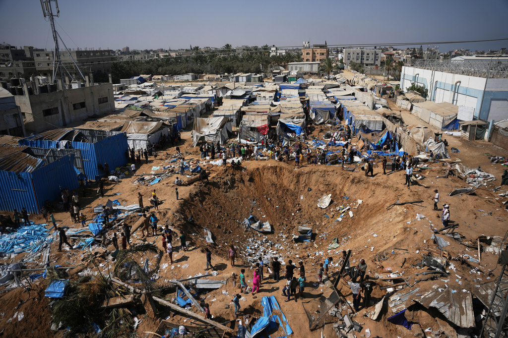 Palestinians inspect the scene of an Israeli airstrike near al-Aqsa Hospital in Deir al-Balah in the central Gaza Strip, Saturday, Aug. 1, 2026. (AP Photo/Abdel Kareem Hana)