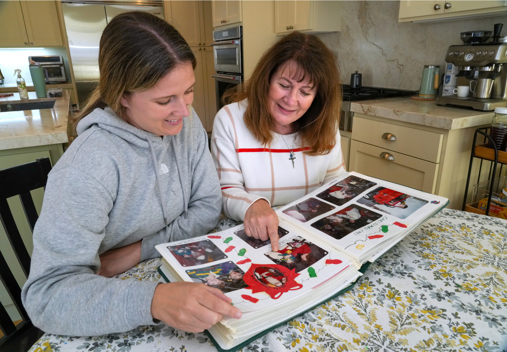 Kelley Nalewaja, right, looks over photos of her son, Michael Nalewaja, who died after unknowingly taking a lethal cocktail of fentanyl and carfentanil in November 2025, with her daughter, Caroline Bendel, at her home in El Dorado Hills, Calif., Thursday, April 16, 2026. (AP Photo/Rich Pedroncelli)