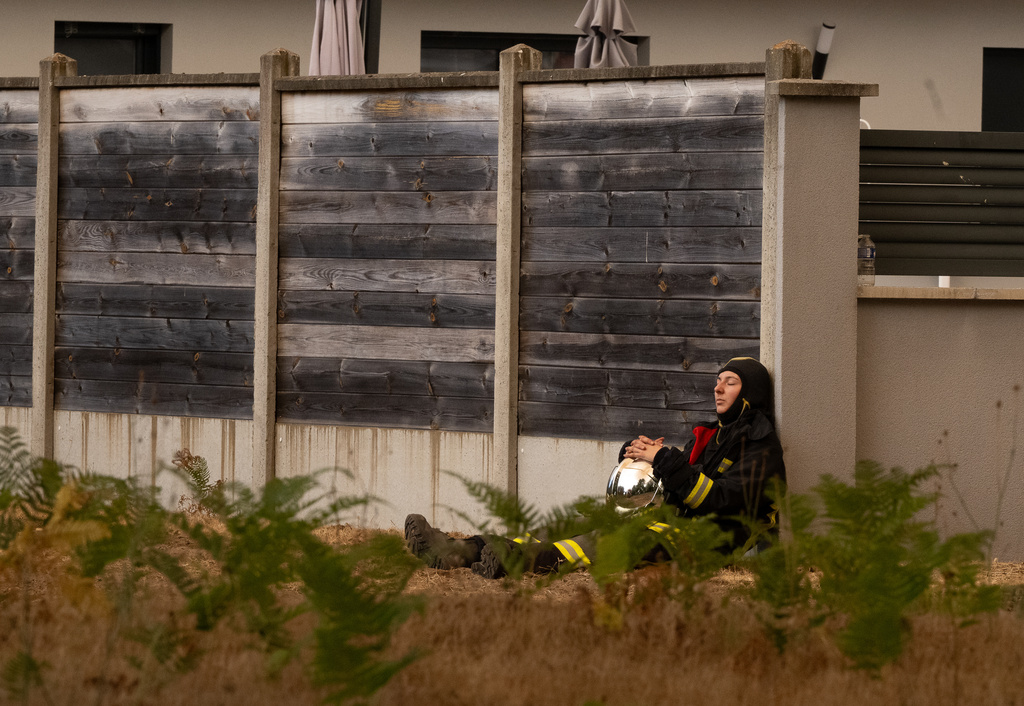 A firefighter rests from battling wildfires, in the Lège-Cap-Ferret region, western France, Thursday, July 23, 2026. (AP Photo/Caroline Blumberg)