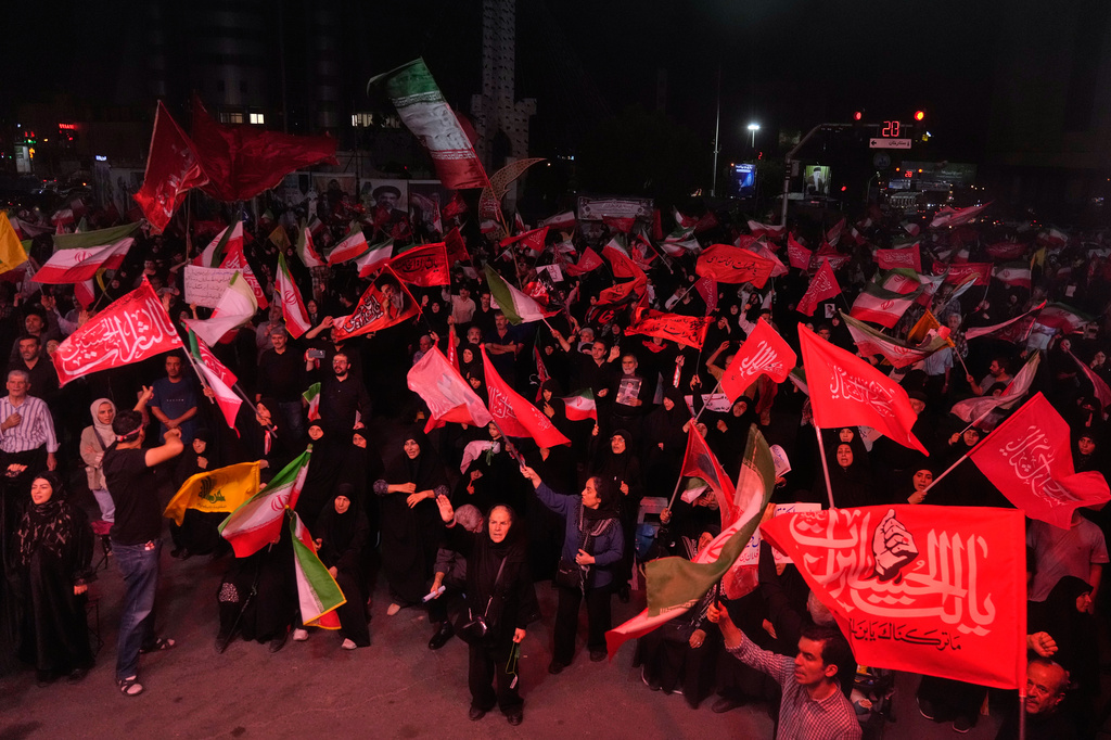 Pro-government demonstrators wave Iranian and religious flags in a gathering commemorating the late Iranian Supreme Leader Ayatollah Ali Khamenei at a square in Tehran, Saturday, July 11, 2026. (AP Photo/Vahid Salemi)