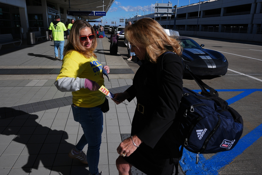 Air Traffic Controller Lisa Blake distributes a leaflet to a traveler explaining how the federal government shutdown is impacting air travel at Detroit Metropolitan Wayne County Airport Tuesday, Oct. 28, 2025, in Romulus, Mich. (AP Photo/Paul Sancya)