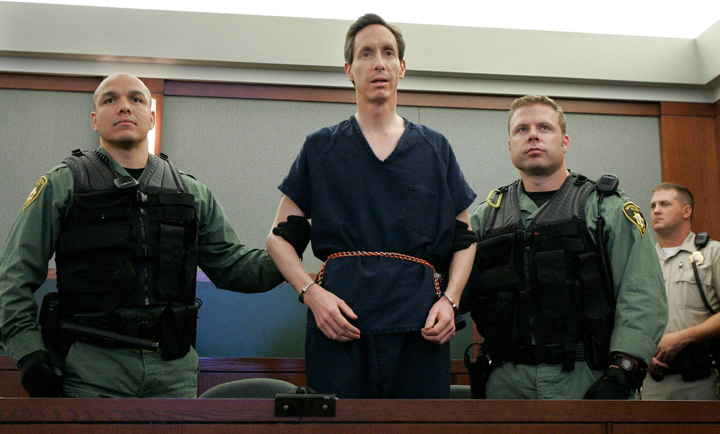 FILE - Polygamous church leader Warren Jeffs appears in a courtroom surrounded by guards in Las Vegas, on Aug. 31, 2006. (AP Photo/Laura Rauch, File)