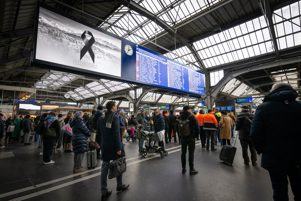 People observe a minute of silence on the national day of mourning, at the main station in Zurich, Switzerland, Friday Jan. 9, 2026, following the deadly fire at the "Le Constellation" bar in Crans-Montana. (Andreas Becker/Keystone via AP)