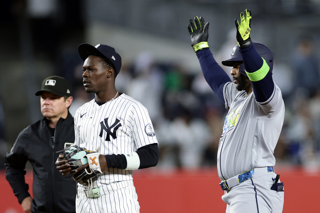 Tampa Bay Rays designated hitter Yandy Díaz reacts next to New York Yankees second baseman Jazz Chisholm Jr. after hitting a two-run scoring single in the ninth inning during the second baseball game of a doubleheader against the New York Yankees, Tuesday, Sept. 22, 2026, in New York. (AP Photo/Adam Hunger)