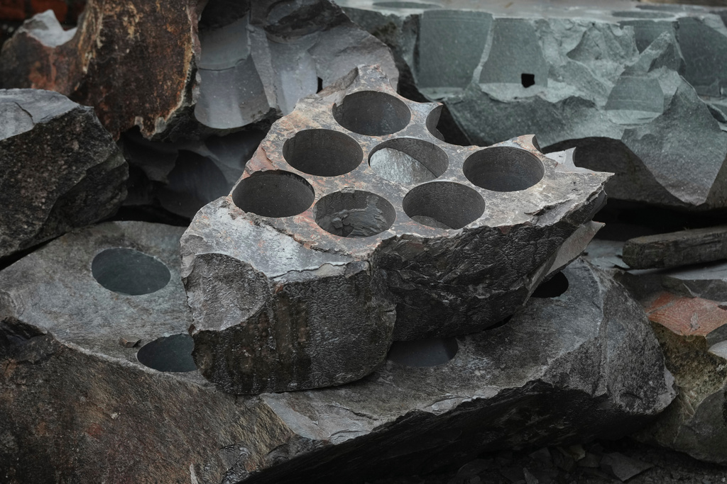 Granite rock that has been used to create curling stone blocks lies outside Kays Curling stone factory in Mauchline, Scotland, Tuesday, Nov. 11, 2025. (AP Photo/Alastair Grant)