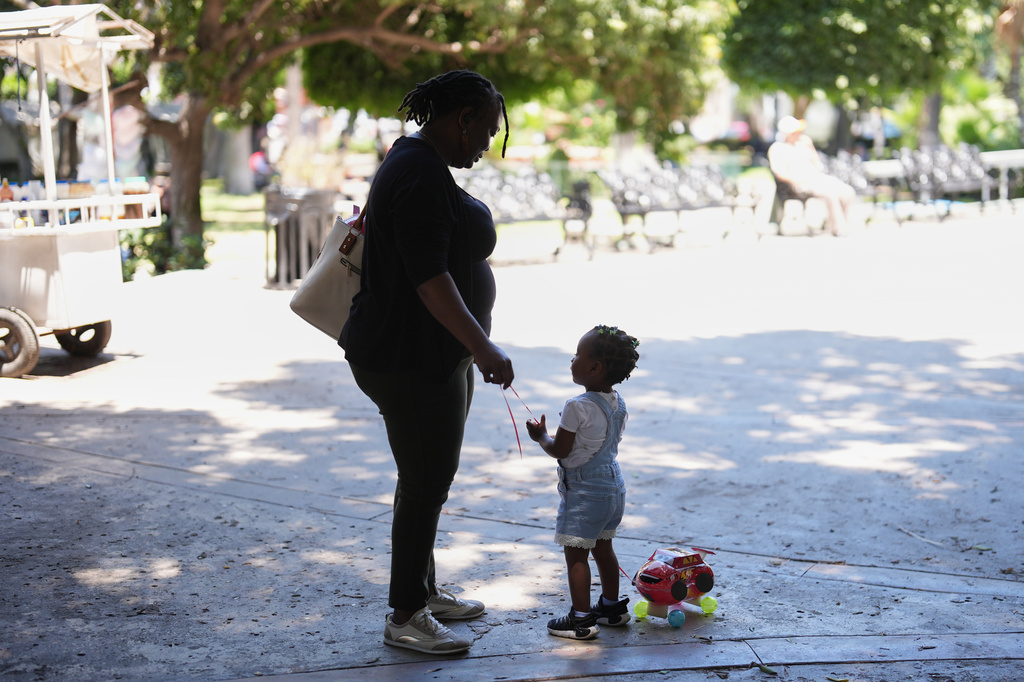 Vivianne Petit Frere talks with granddaughter Alexca at a park, June 22, 2026, in Tijuana, Mexico. (AP Photo/Gregory Bull)
