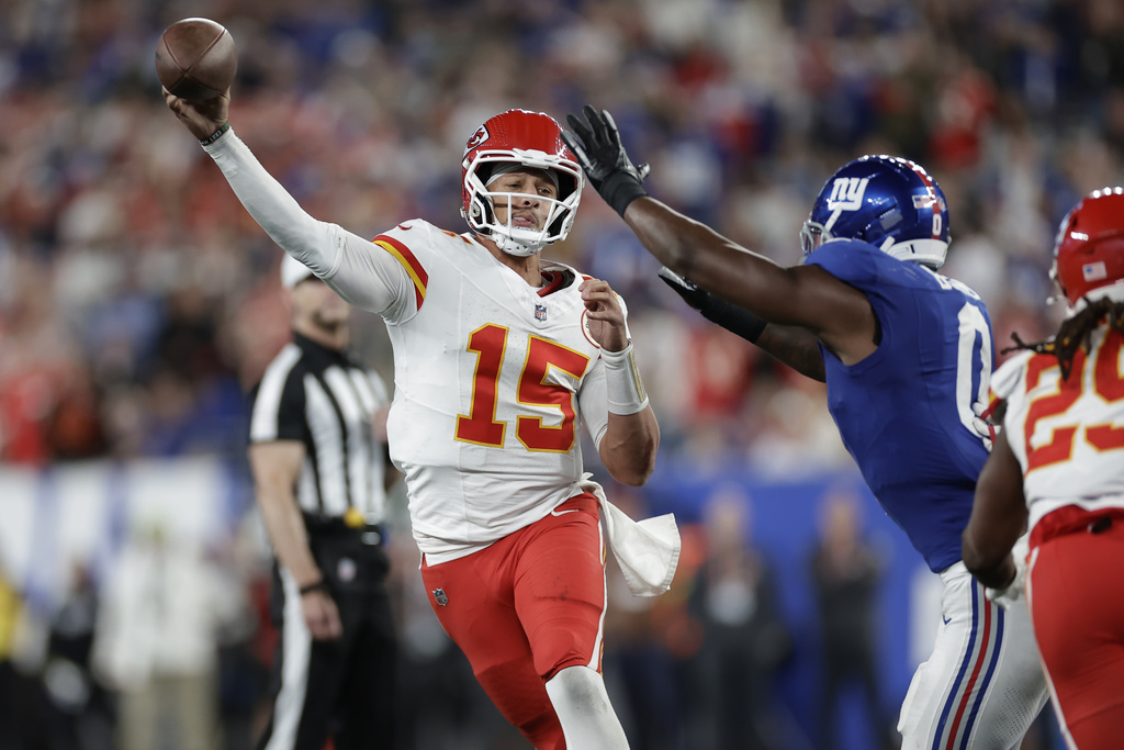 Kansas City Chiefs quarterback Patrick Mahomes (15) throws under pressure from New York Giants outside linebacker Brian Burns (0) during the first half of an NFL football game Sunday, Sept. 21, 2025, in East Rutherford, N.J. (AP Photo/Adam Hunger)