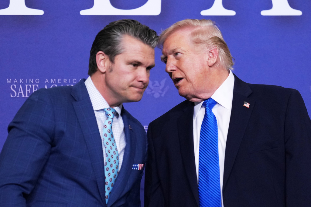 President Donald Trump speaks with Defense Secretary Pete Hegseth during a roundtable discussion on public safety at a Tennessee Air National Guard Base, Monday, March 23, 2026, in Memphis, Tenn. (AP Photo/Mark Schiefelbein)