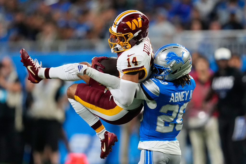 Washington Commanders wide receiver Antonio Williams (14) makes a catch against Detroit Lions cornerback Keith Abney II (28) during a preseason NFL football game, Saturday, Aug. 22, 2026, in Detroit. (AP Photo/Paul Sancya)