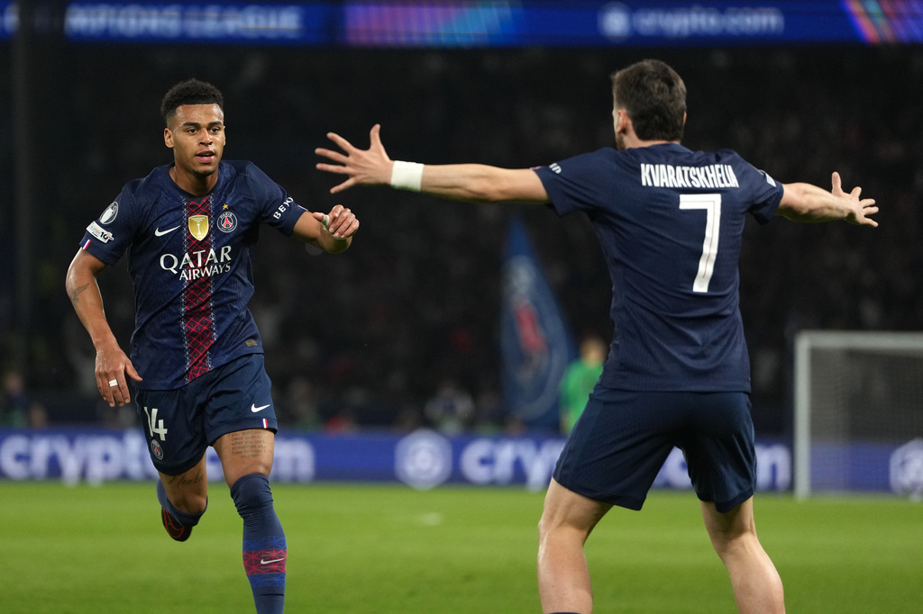 PSG's Desire Doue, left, celebrates with PSG's Khvicha Kvaratskhelia after scoring the opening goal during the Champions League quarterfinal first leg soccer match between Paris Saint-Germain and Liverpool in Paris, Wednesday, April 8, 2026. (AP Photo/Thibault Camus)