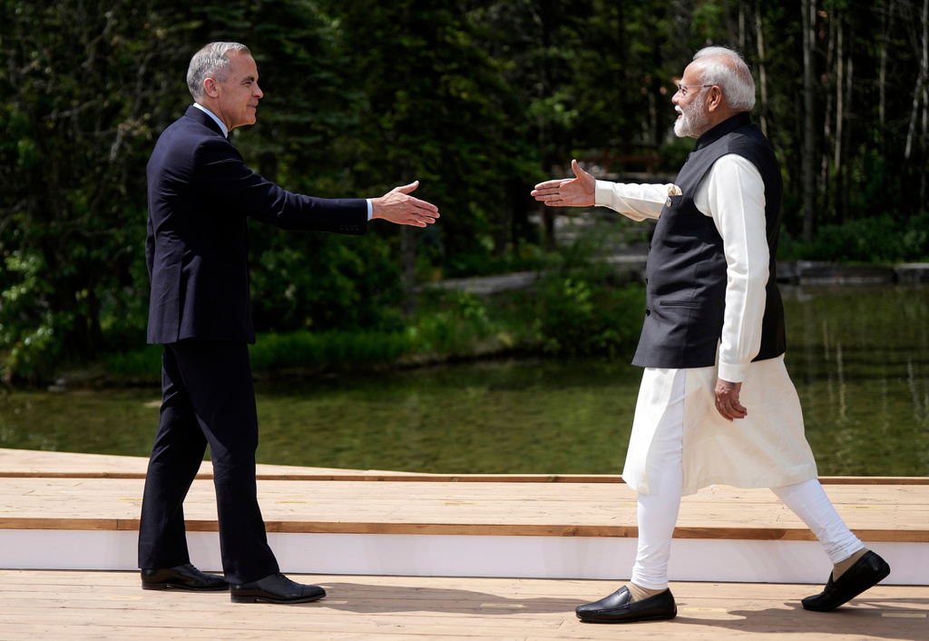 FILE - Canada's Prime Minister Mark Carney, left, and India's Prime Minister Narendra Modi reach to shake hands at the G7 Summit in Kananaskis, Alberta, June 17, 2025. (Darryl Dyck/The Canadian Press via AP, File)