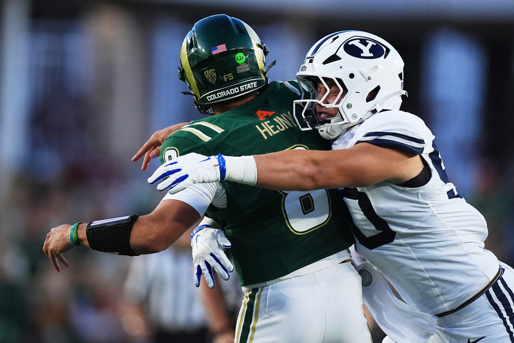 BYU defensive end Hunter Clegg, right, hits Colorado State quarterback Hauss Hejny as he throws a pass in the first half of an NCAA college football game Saturday, Sept. 19, 2026, in Fort Collins, Colo. (AP Photo/David Zalubowski)