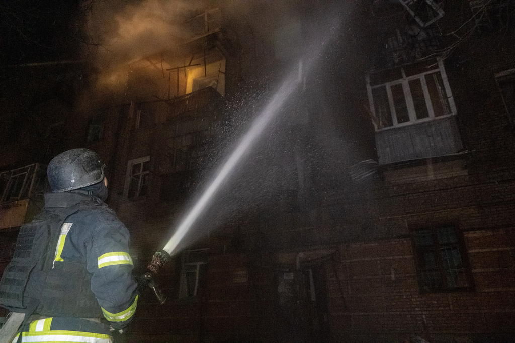 Emergency services personnel work to extinguish a fire following a Russian attack in Kharkiv, Ukraine, Saturday, Jan. 24, 2026. (AP Photo/Andrii Marienko)