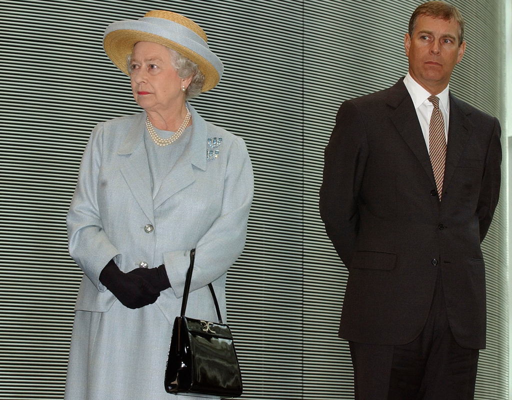 FILE - Britain's Queen Elizabeth II stands next to her son Prince Andrew as they listen to speeches during a visit to Imperial College in London, June 24, 2004. (AP Photo/Richard Lewis, File)