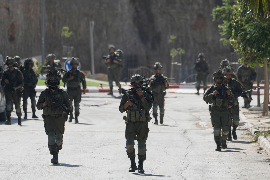 Israeli army soldiers patrol the streets of the occupied West Bank village of Qusra, south of Nablus, Thursday, Aug. 13, 2026. (AP Photo/Majdi Mohammed)