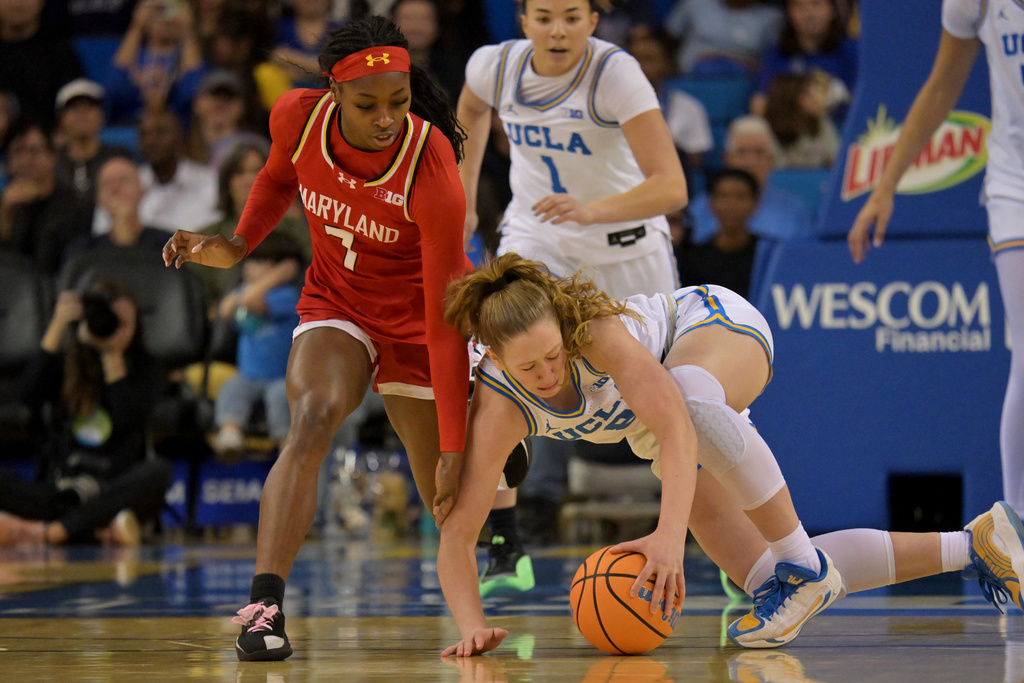 Maryland guard Oluchi Okananwa, left, and UCLA guard Gianna Kneepkens, front right, reach for the ball during the first half of an NCAA college basketball game Sunday, Jan. 18, 2026, in Los Angeles. (AP Photo/Jayne Kamin-Oncea)