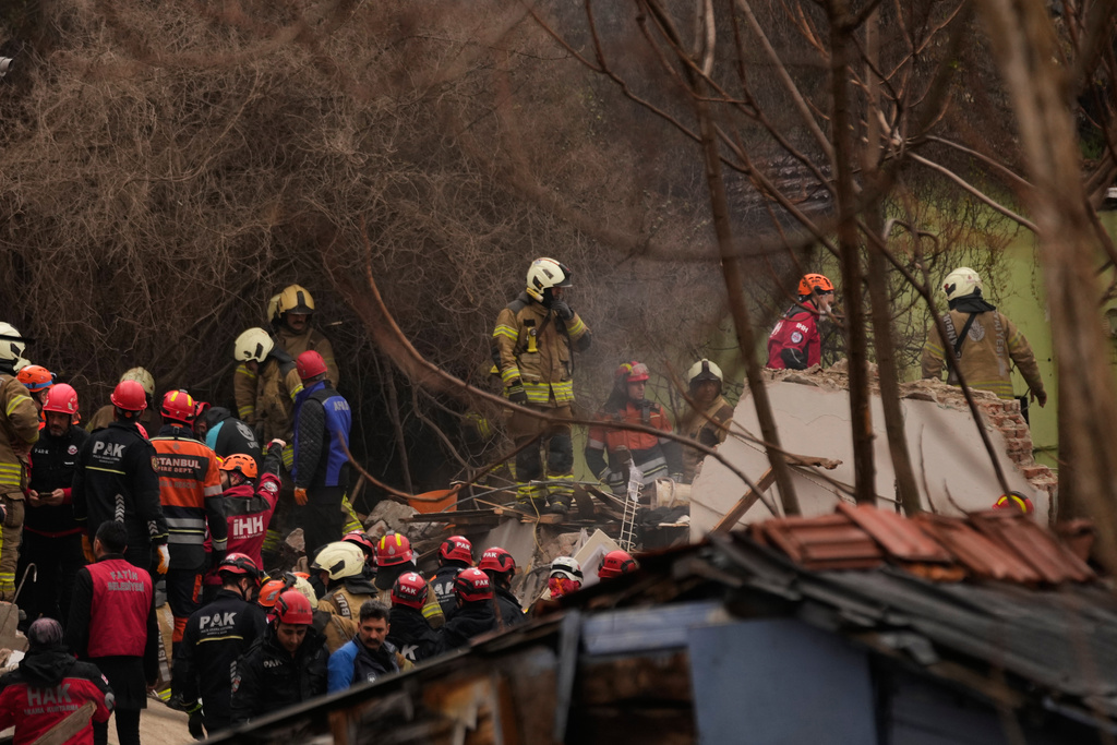 Rescue teams and firefighters search the site where two residential buildings collapsed in Istanbul, Sunday, March 22, 2026. (AP Photo/Khalil Hamra)