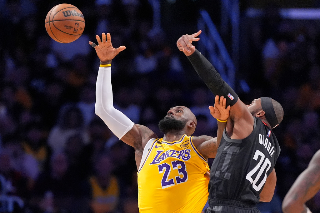 Los Angeles Lakers forward LeBron James, left, takes a pass as Houston Rockets guard Josh Okogie defends during the first half in Game 1 of a first-round NBA playoffs basketball series Saturday, April 18, 2026, in Los Angeles. (AP Photo/Mark J. Terrill)