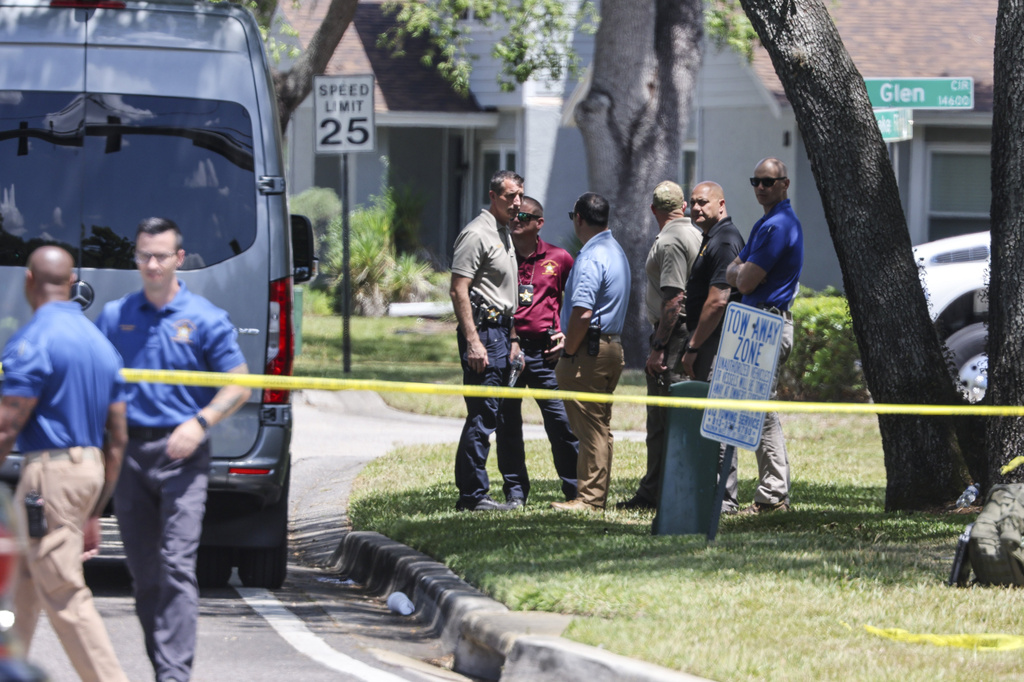Detectives with the Hillsborough County Sheriff's Office join an investigation inside the Lake Forest subdivision of Tampa, Fla., on Friday, April 24, 2026, where authorities said a man was taken into custody after barricading himself inside a home, in connection to the search for two missing University of South Florida graduate students. (Douglas R. Clifford/Tampa Bay Times via AP)