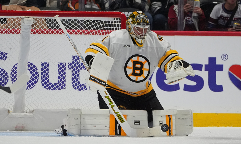 Boston Bruins goaltender Jeremy Swayman makes a stick-save in the second period of an NHL hockey game against the Colorado Avalanche, Saturday, Oct. 18, 2025, in Denver. (AP Photo/David Zalubowski)