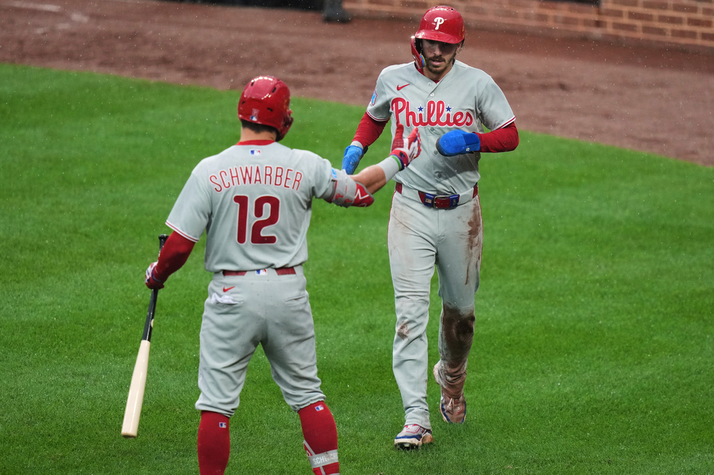 Philadelphia Phillies' Bryson Stott, right, celebrates with Kyle Schwarber (12) after scoring on a sacrifice flyout hit by Bryan de la Cruz during the sixth inning of a baseball game against the Baltimore Orioles, Sunday, Aug. 2, 2026, in Baltimore. (AP Photo/Stephanie Scarbrough)