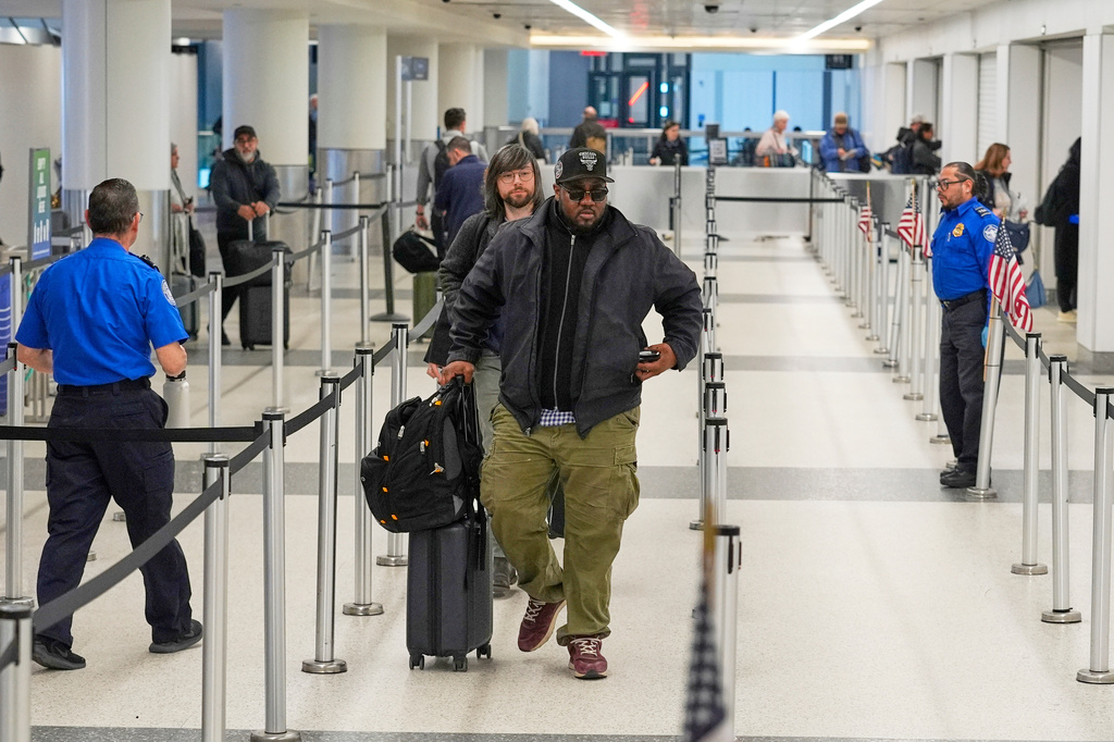 Travelers move quickly through the security lanes at a TSA security checkpoint in Terminal B, Friday, March 27, 2026, at Logan International Airport in Boston. (AP Photo/Robert F. Bukaty)