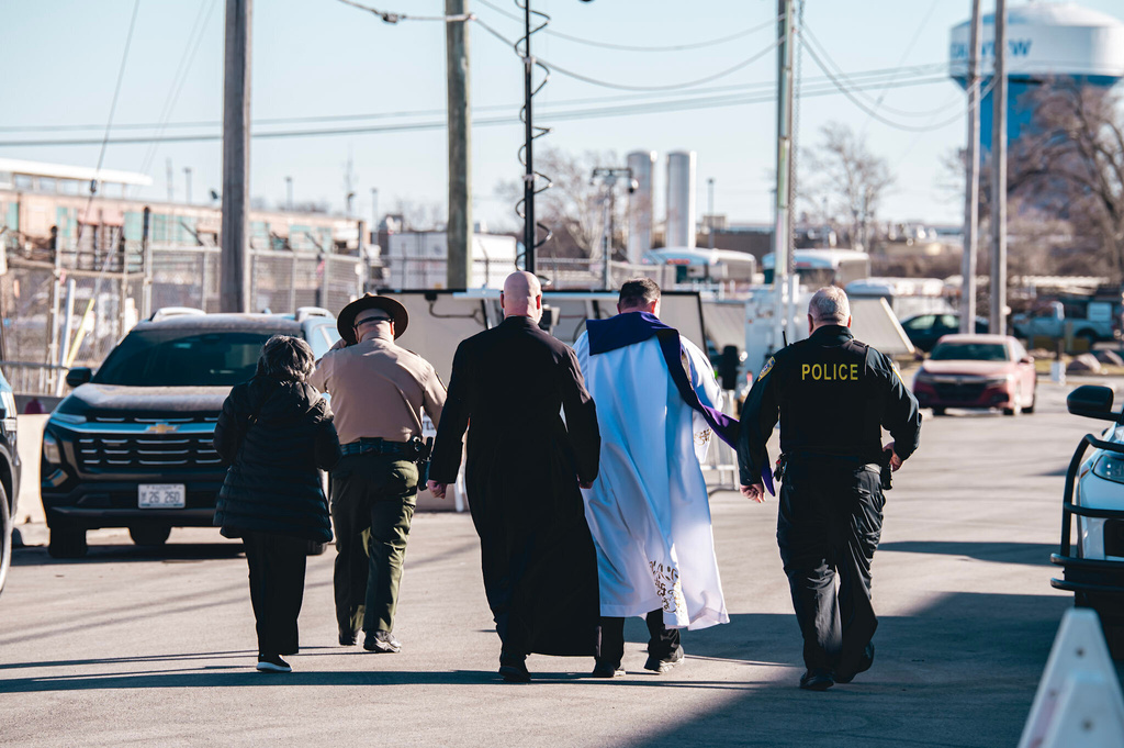 In this photo provided by the Coalition for Spiritual and Public Leadership, Father Leandro Fossá, CS, Fr. Paul Keller, CMF, and Sr. Alicia Gutierrez, SH, are escorted by police officers into the Broadview detention center in Broadview, Ill., on Ash Wednesday, Feb. 18, 2026. (Derek Carter/Coalition for Spiritual and Public Leadership via AP)