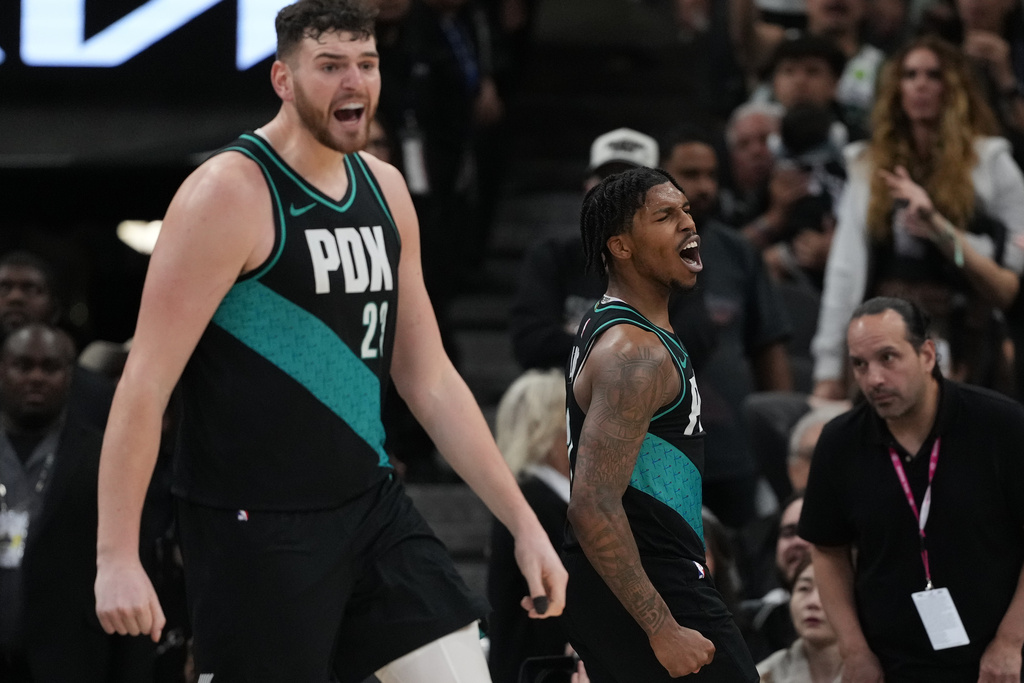 Portland Trail Blazers guard Caleb Love, right, and center Donovan Clingan, left, react to a play during the second half of an NBA basketball game against the San Antonio Spurs in San Antonio, Saturday, Jan. 3, 2026. (AP Photo/Eric Gay)