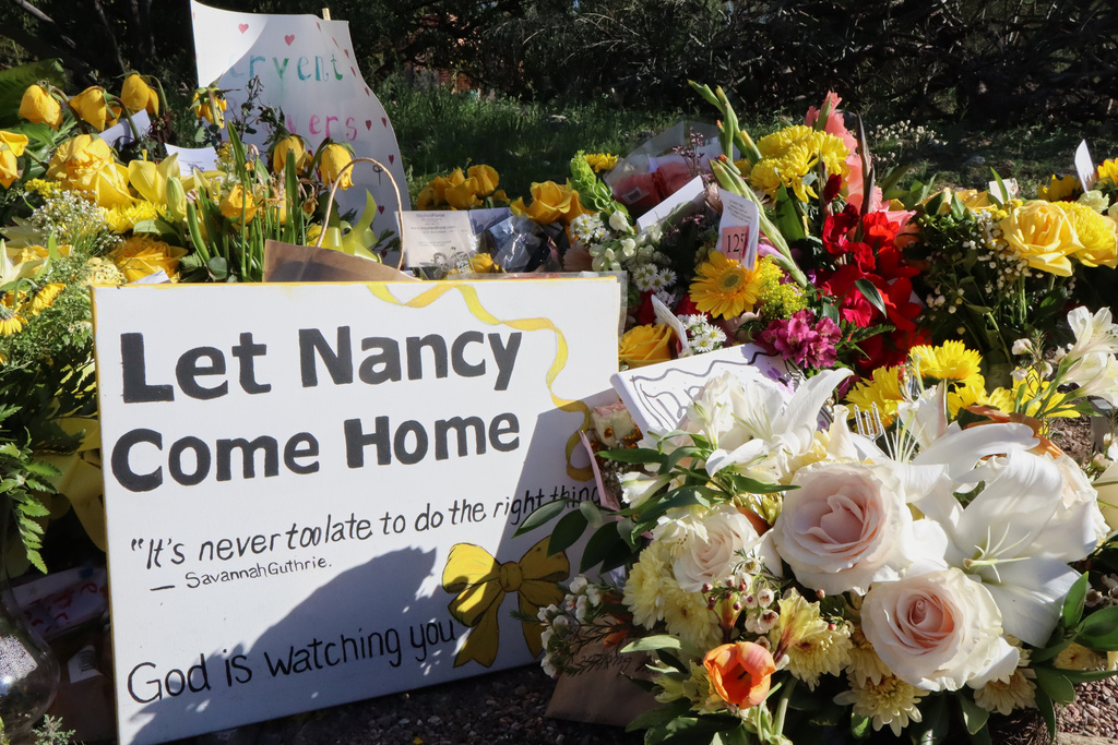 A memorial grows outside the home of Nancy Guthrie, the missing mother of "Today" show host Savannah Guthrie, on Sunday, Feb. 22, 2026, in Tucson, Ariz. (AP Photo/Felicia Fonseca)