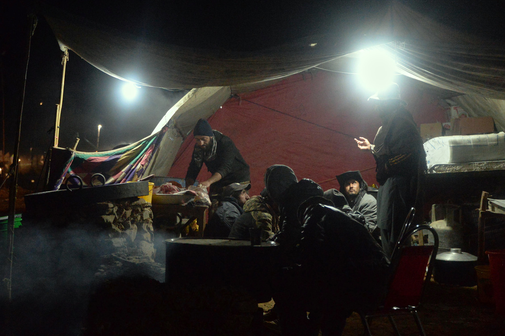 Spectators eat a meal at a makeshift food stall at a temporary settlement made of tents during the three-day annual Shandur Polo Festival in Shandur Pass, in the Ghizer district of Gilgit-Baltistan, northern Pakistan, Thursday, June 11, 2026. (AP Photo/Zubair Abbasi)