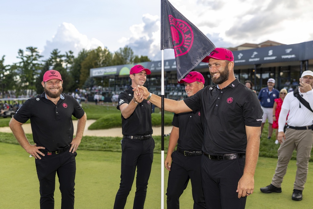 Team Champions captain Jon Rahm, front right, Tyrrell Hatton, left, Caleb Surratt, third from left, and Tom McKibbin, second from left, of Legion XIII, stand near their pin flag on the 18th green following the final round of LIV Golf Team Championship Michigan at The Cardinal at Saint John's, Sunday, Aug. 24, 2025, in Plymouth, Mich. (Scott Taetsch/LIV Golf via AP)